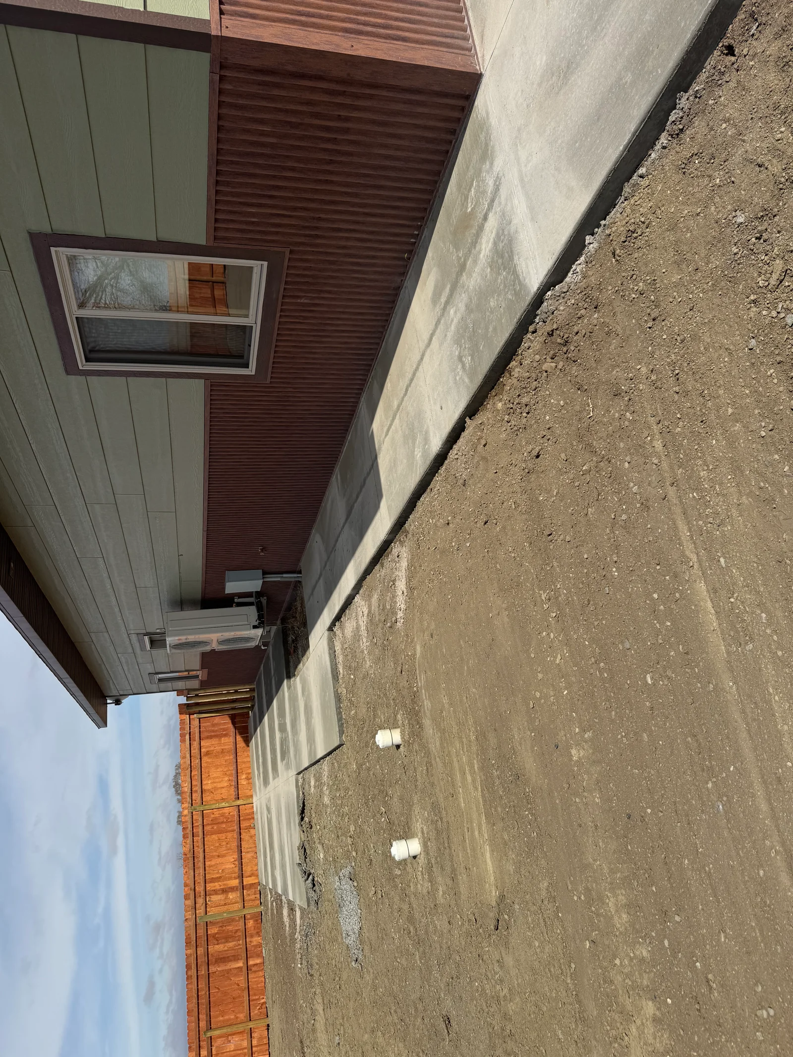 Concrete foundation wall with finished surface and proper grading for residential construction