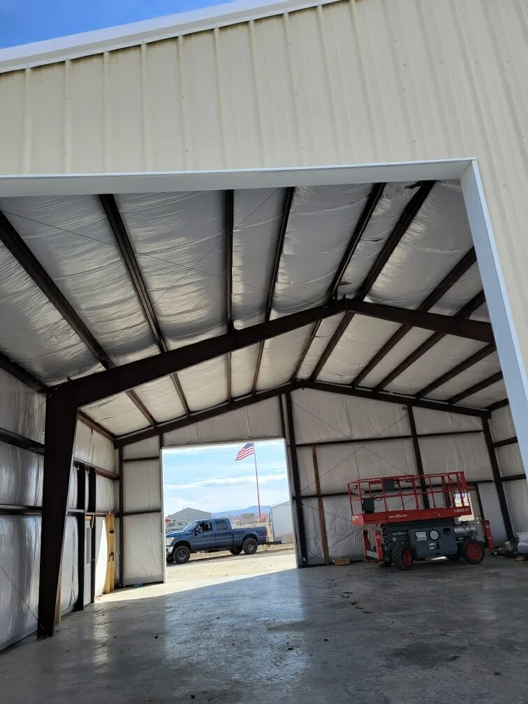 Steel frame building interior with polycarbonate panels, black beams, and concrete floor
