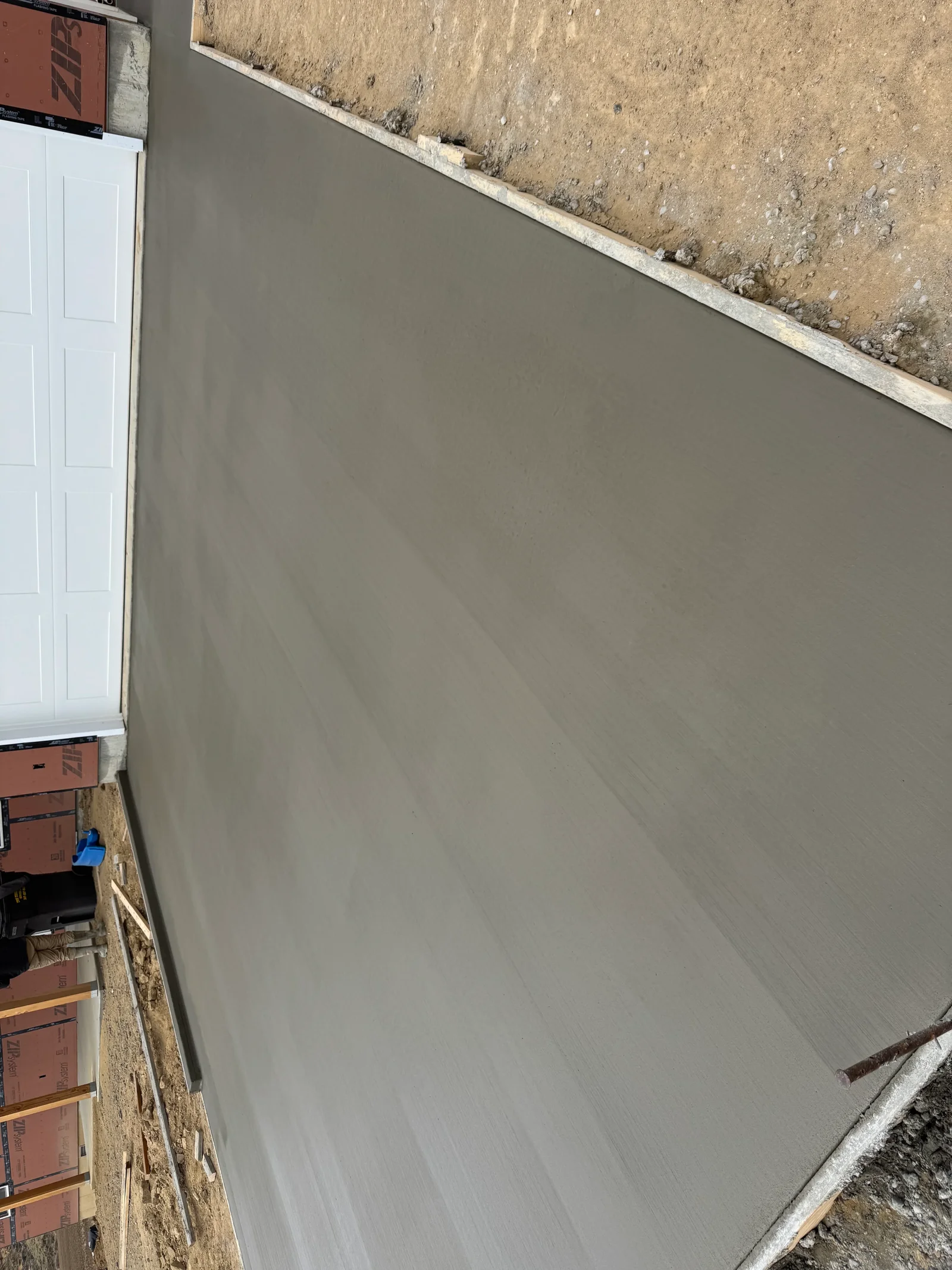 Newly poured concrete driveway with smooth finish and concrete edge borders