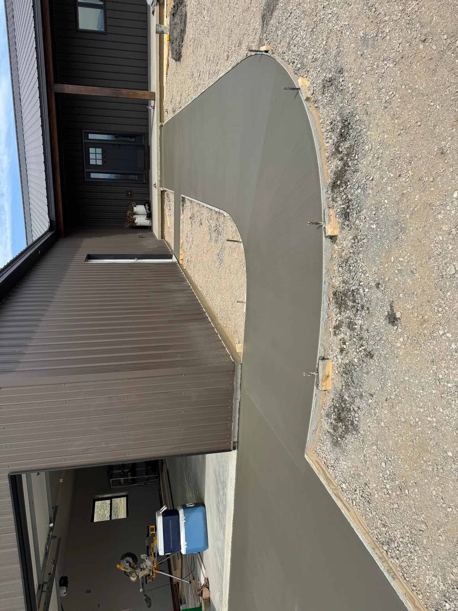 Freshly poured gray concrete driveway with smooth finish and proper slope for drainage