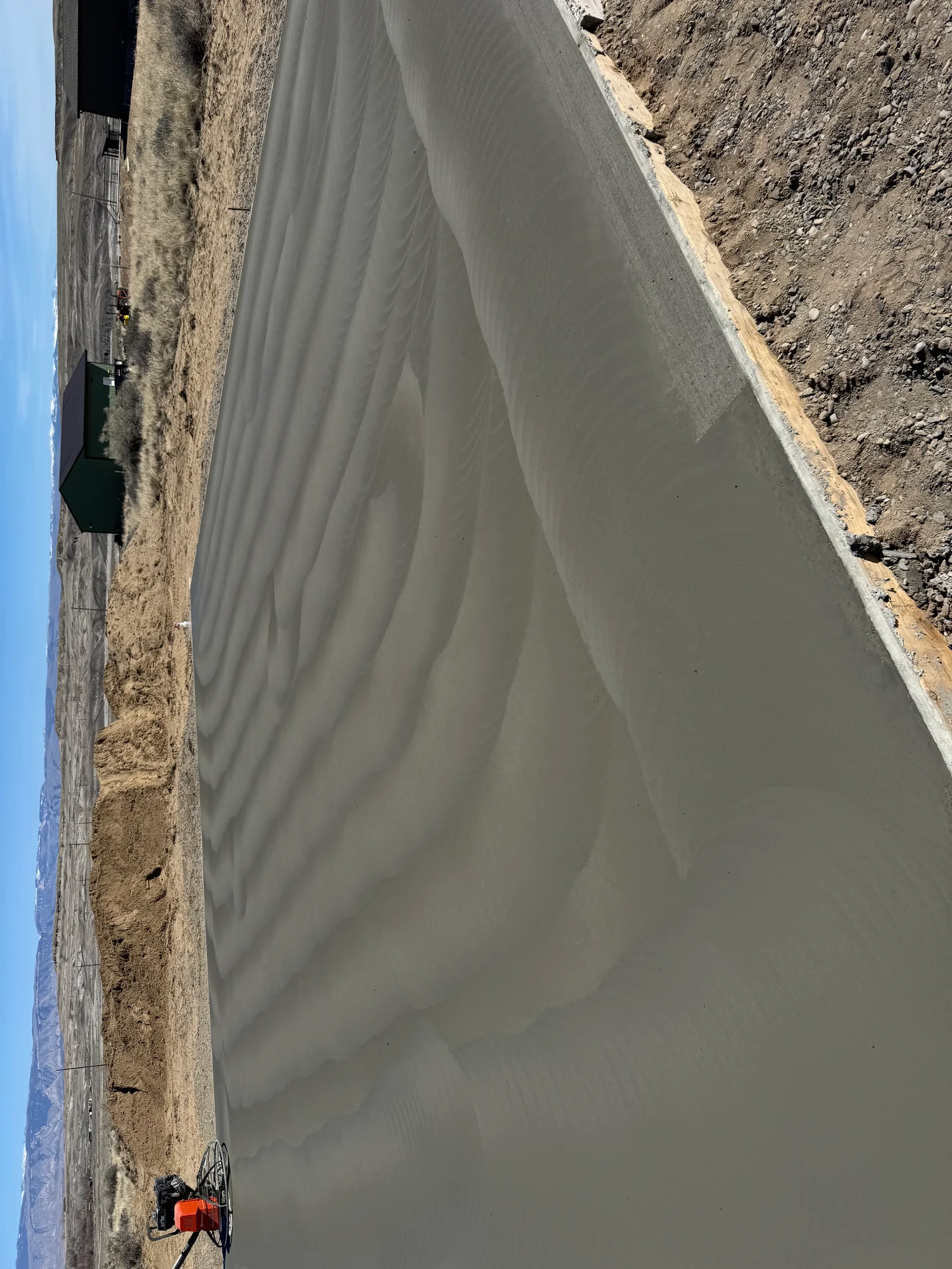 Newly poured concrete driveway with smooth finish and proper slope for drainage