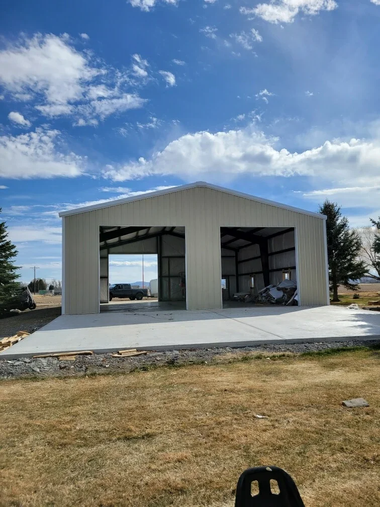 Metal-frame garage with corrugated steel siding, gable roof, and concrete foundation