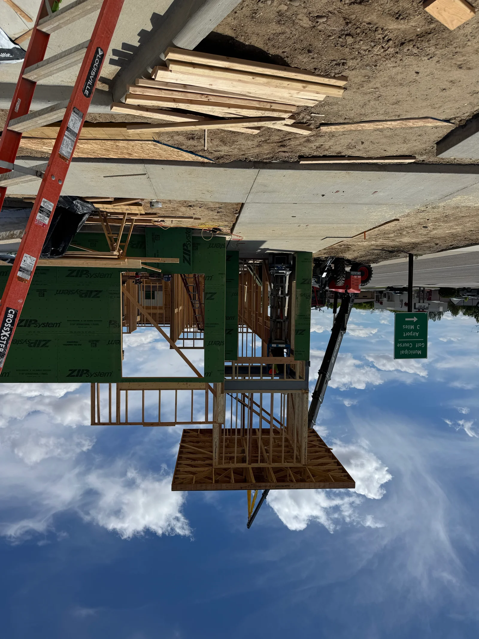 Wood framing, floor joists, wall studs, and roof trusses with green house wrap sheathing