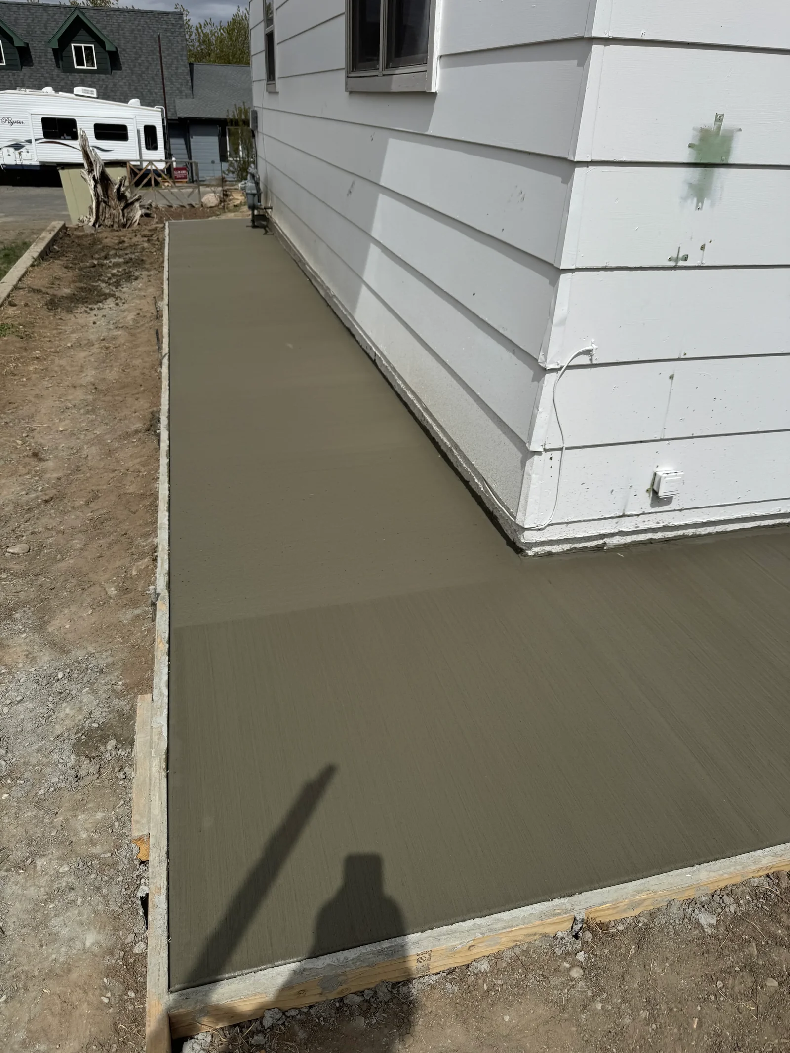 Freshly poured concrete foundation and walkway with wooden forms and steel reinforcement