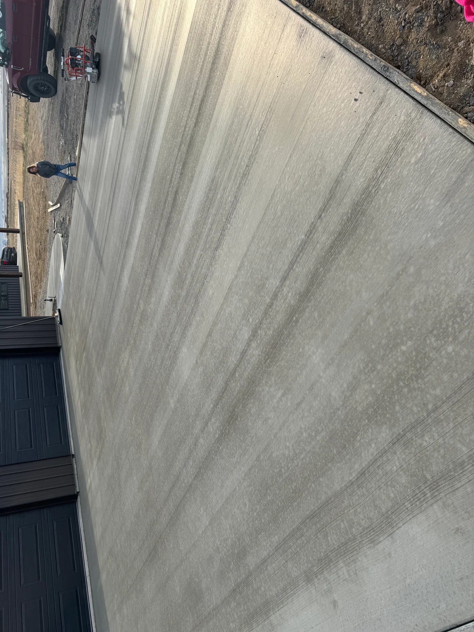 Finished concrete driveway with smooth trowel surface and proper drainage slope