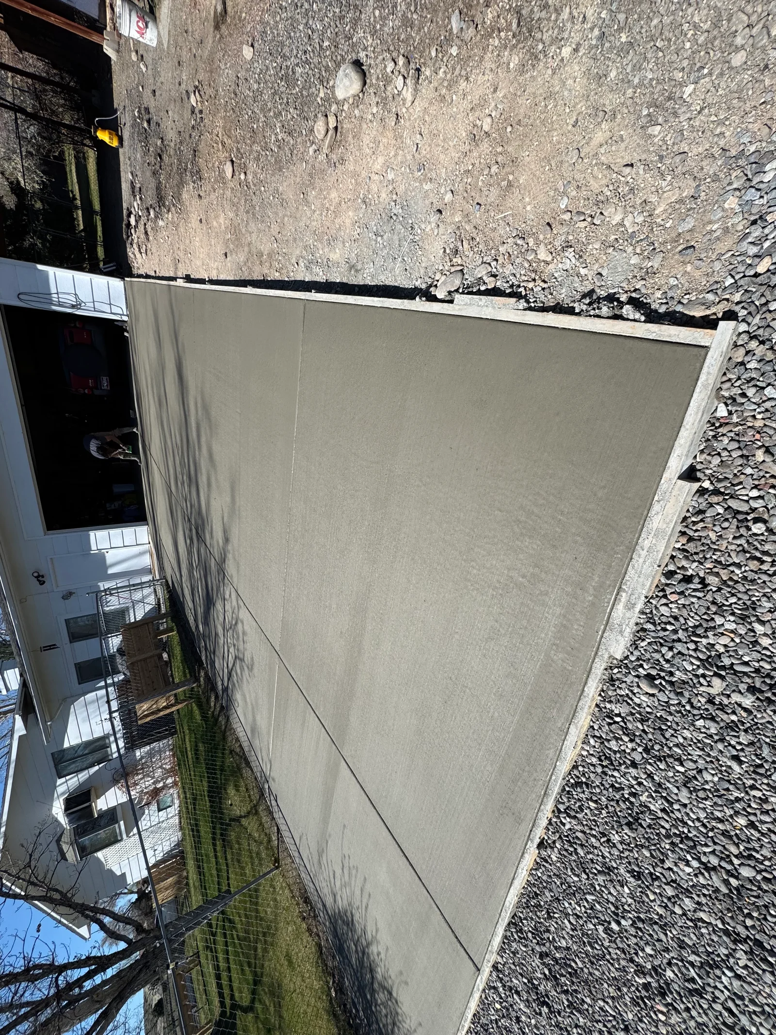Newly poured concrete driveway with finished edges and gravel base